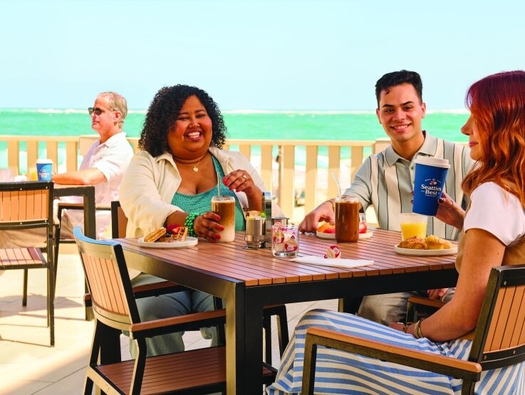 people sitting at tables outside enjoying coffee
