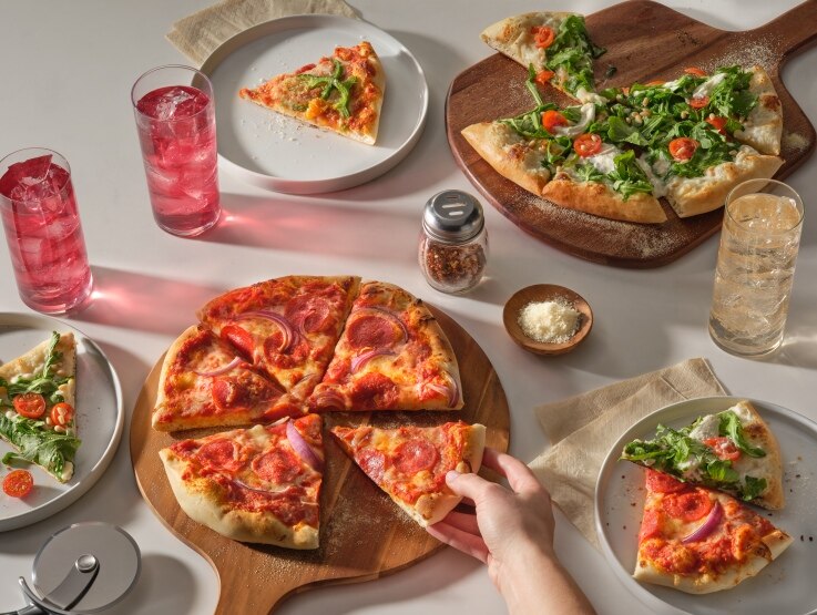 custom off the shelf foods pizza on cutting board and plates