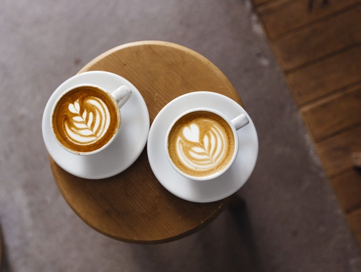 two cups of coffee in white cups on table