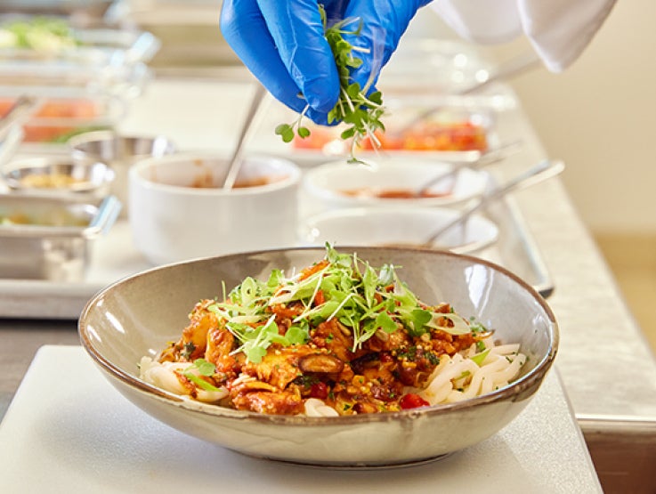 Chef adding garnish to plate of food