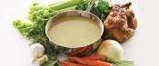 Pot of chicken stock with roasted chicken and assorted produce