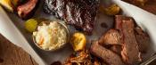 Barbecue smoked brisket and ribs platter in rustic setting