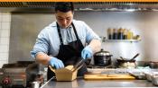 Chef adding food to to-go container