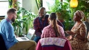 People gathered around a table with laptop