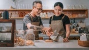 man and woman behind a counter pouring drinks