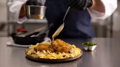 chef adding sauce to plated meal