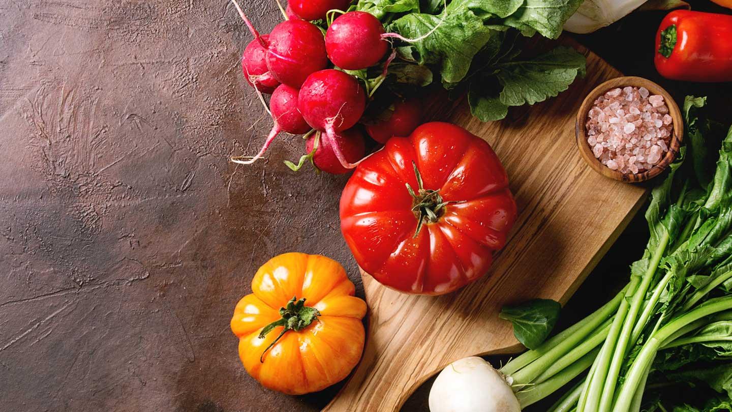 a bunch of vegetables on a chopping block