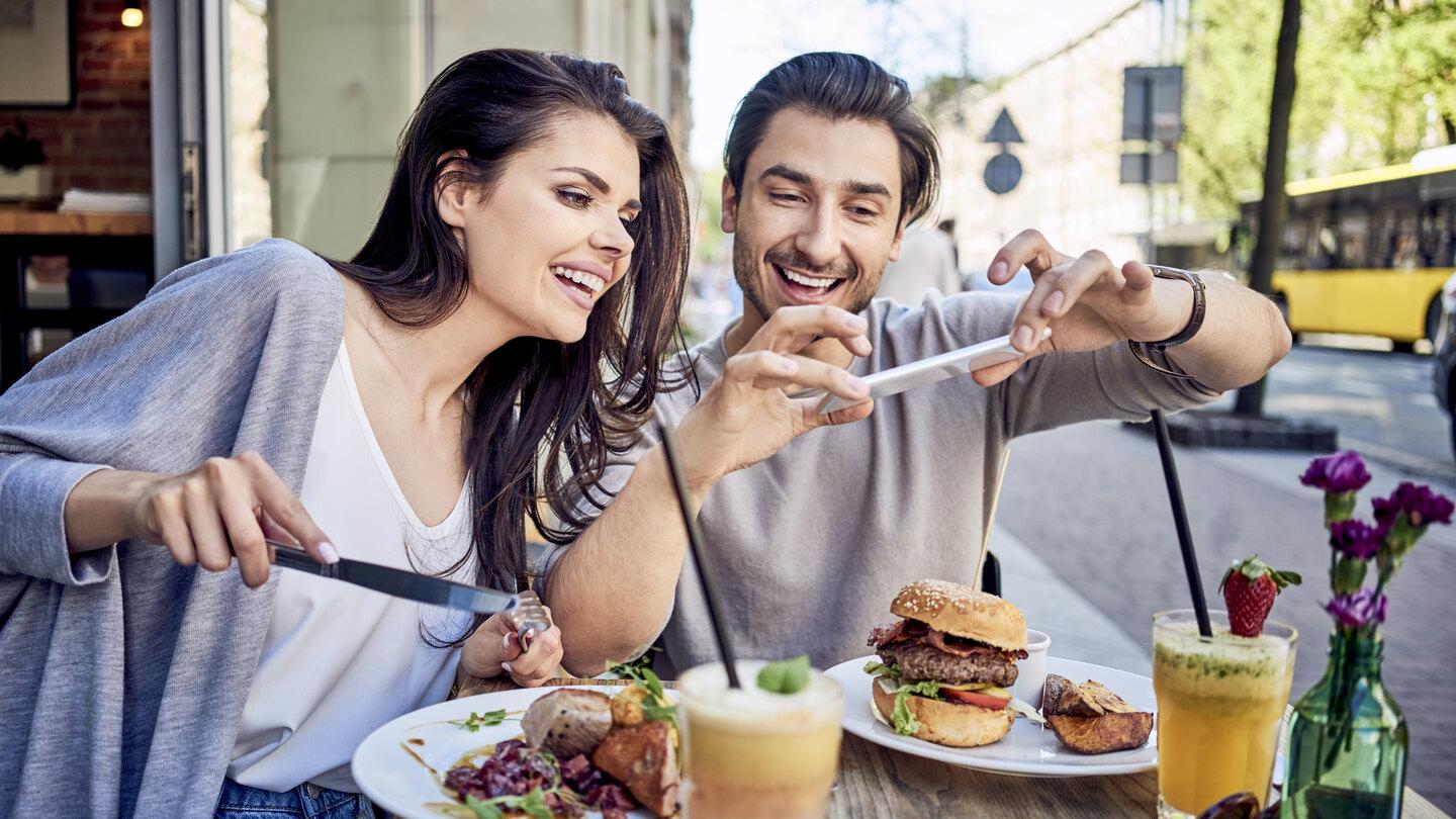 couple taking a picture of their food